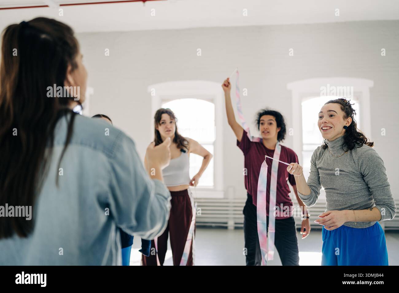 Groupe de danseurs divers apprenant des mouvements rythmiques de ruban Banque D'Images