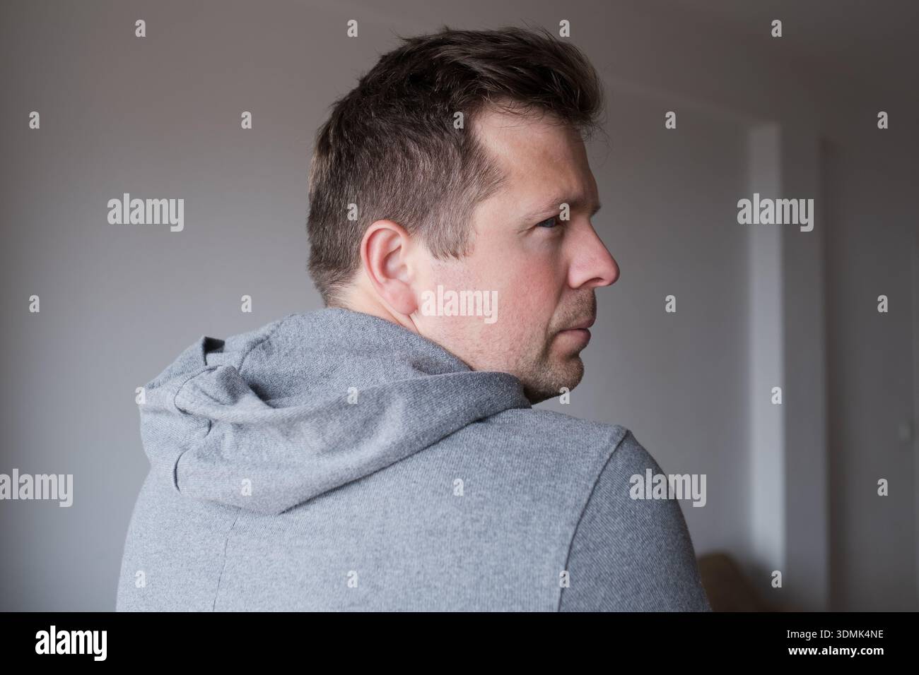 Offensé l'homme tournant le dos et regardant en arrière par-dessus son épaule avec ressentiment Banque D'Images
