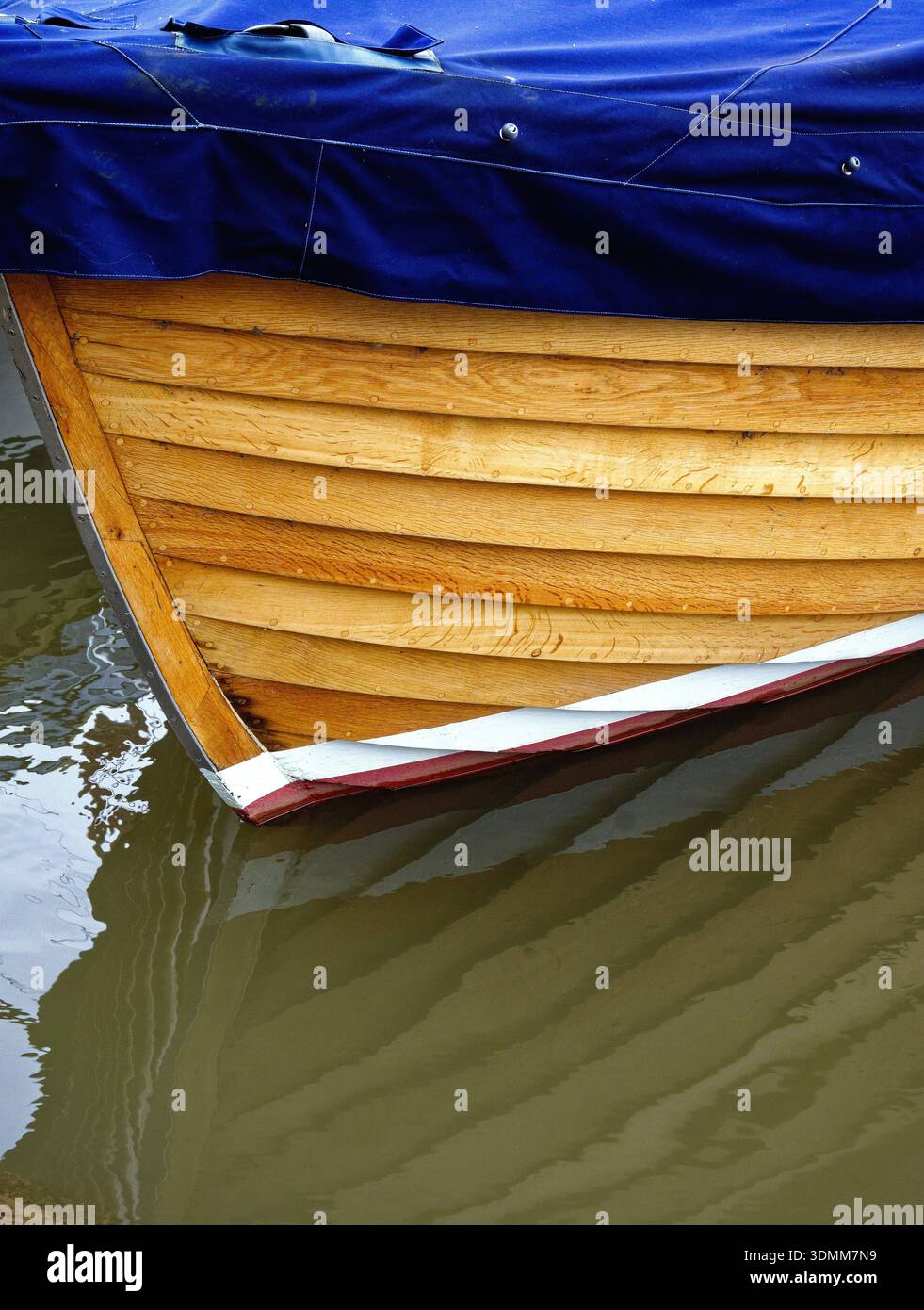 Gros plan de la coque en bois de clinker construit petit bateau à flot sur l'eau formant un motif abstrait Banque D'Images