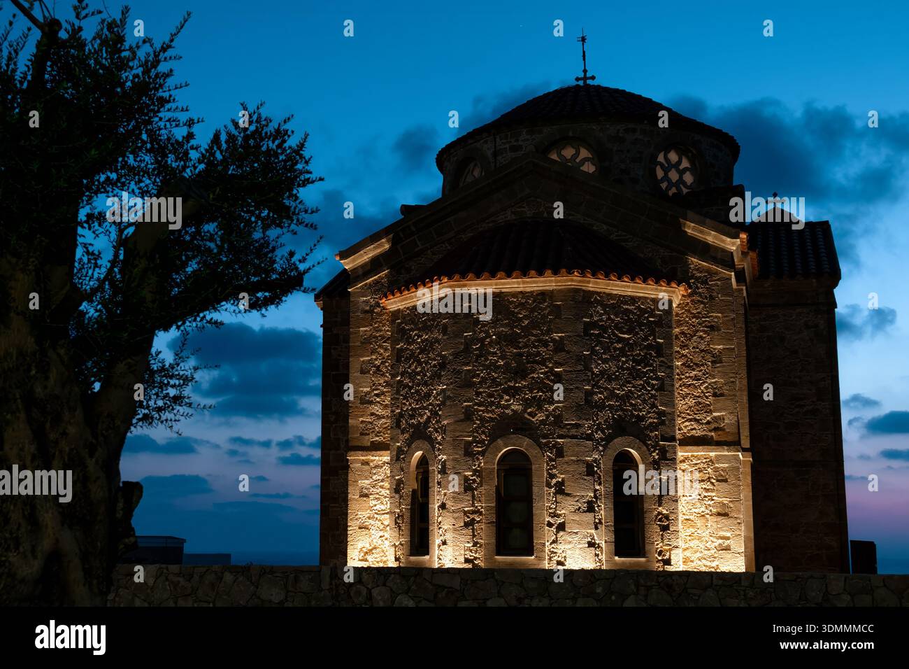 Église d'Agios Georgios architecture ancienne en pierre illuminant le ciel nocturne au crépuscule, monument religieux Banque D'Images