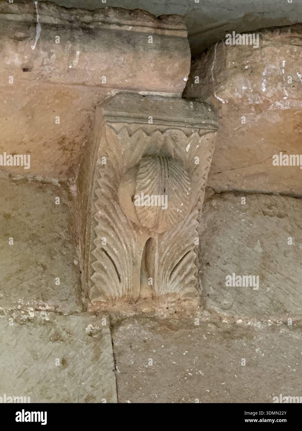 Corbeau de pierre avec fig. sculpter de corbeau de pierre romane sculpté avec une figure humaine sous des poutres de toit en bois.URE à l'église Santa Eugenia à Dehe Banque D'Images