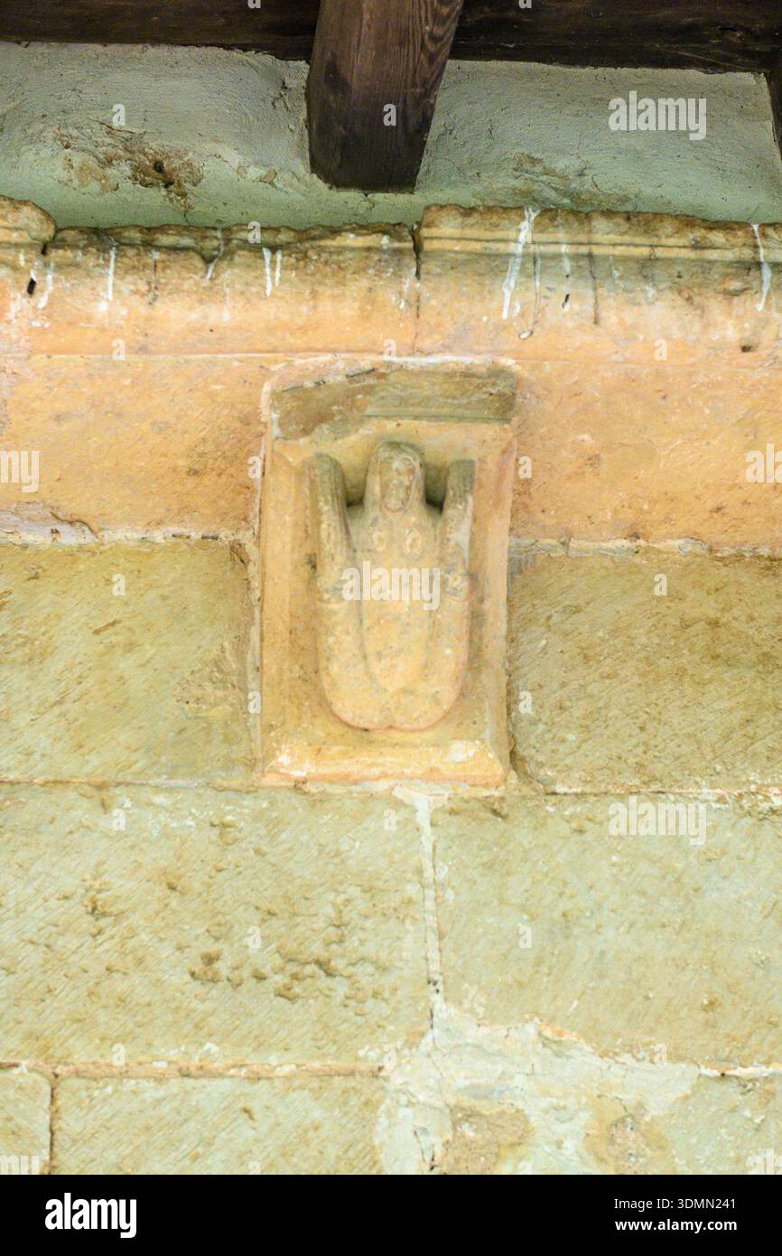 Corbeau de pierre avec fig. sculpter de corbeau de pierre romane sculpté avec une figure humaine sous des poutres de toit en bois.URE à l'église Santa Eugenia à Dehe Banque D'Images