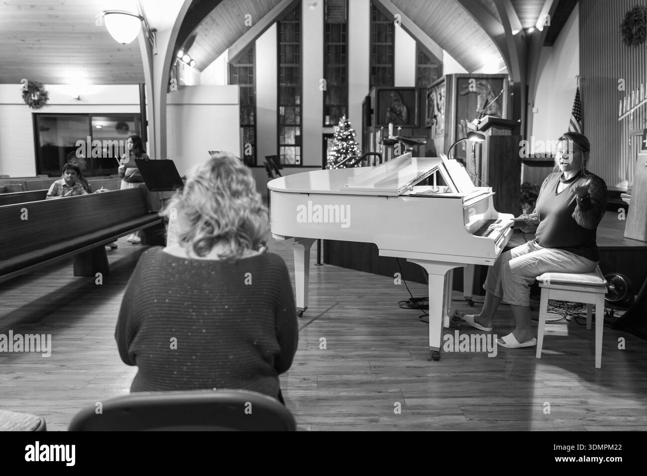 Les membres de l'Église congrégationnelle de Waiokeola se sont réunis avant leur service annuel de la veille de Noël à Honolulu, Hawaï. Un pianiste dirige le congrès Banque D'Images