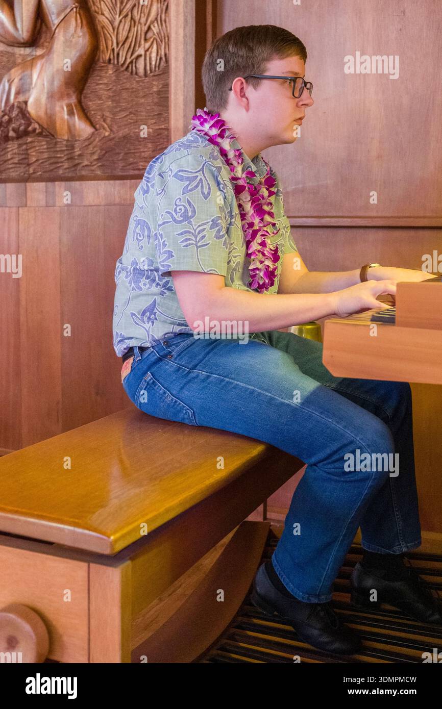 Un organiste se produit lors d'un culte à l'église congrégationnelle de Waiokeola à Kahala, Honolulu, Hawaï. Le musicien est assis à une orga tracker Banque D'Images