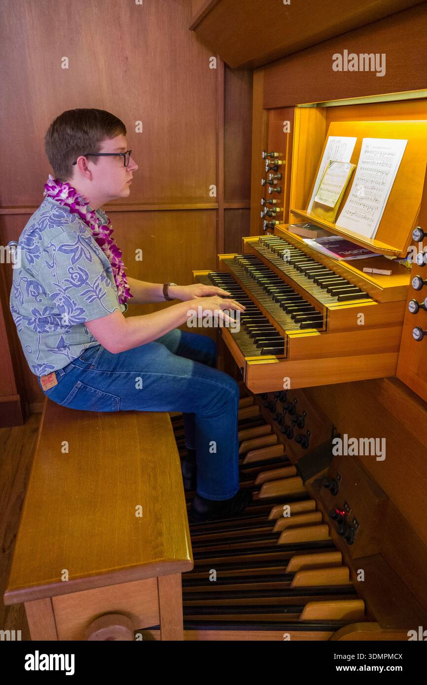 Un homme joue de l'orgue tracker lors d'un culte à l'église congrégationnelle de Waiokeola à Honolulu, Hawaï. L'orgue comporte à la fois manuel et péda Banque D'Images