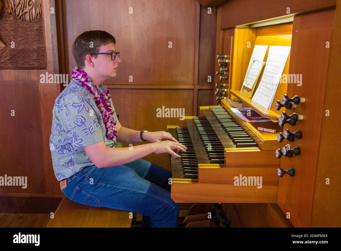 Un organiste se produit lors d'un culte à l'église congrégationnelle de Waiokeola à Kahala, Honolulu, Hawaï. Le musicien est assis à une orga tracker Banque D'Images