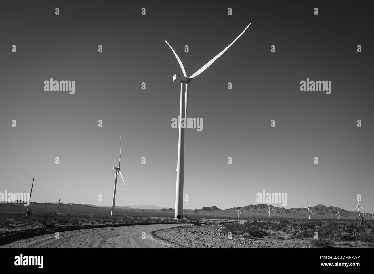 Un moulin à vent électrique géant avec la lune montrant à travers ses pales. Un parc éolien solaire entre Kingman AZ et Las Vegas Nevada. Noir a Banque D'Images