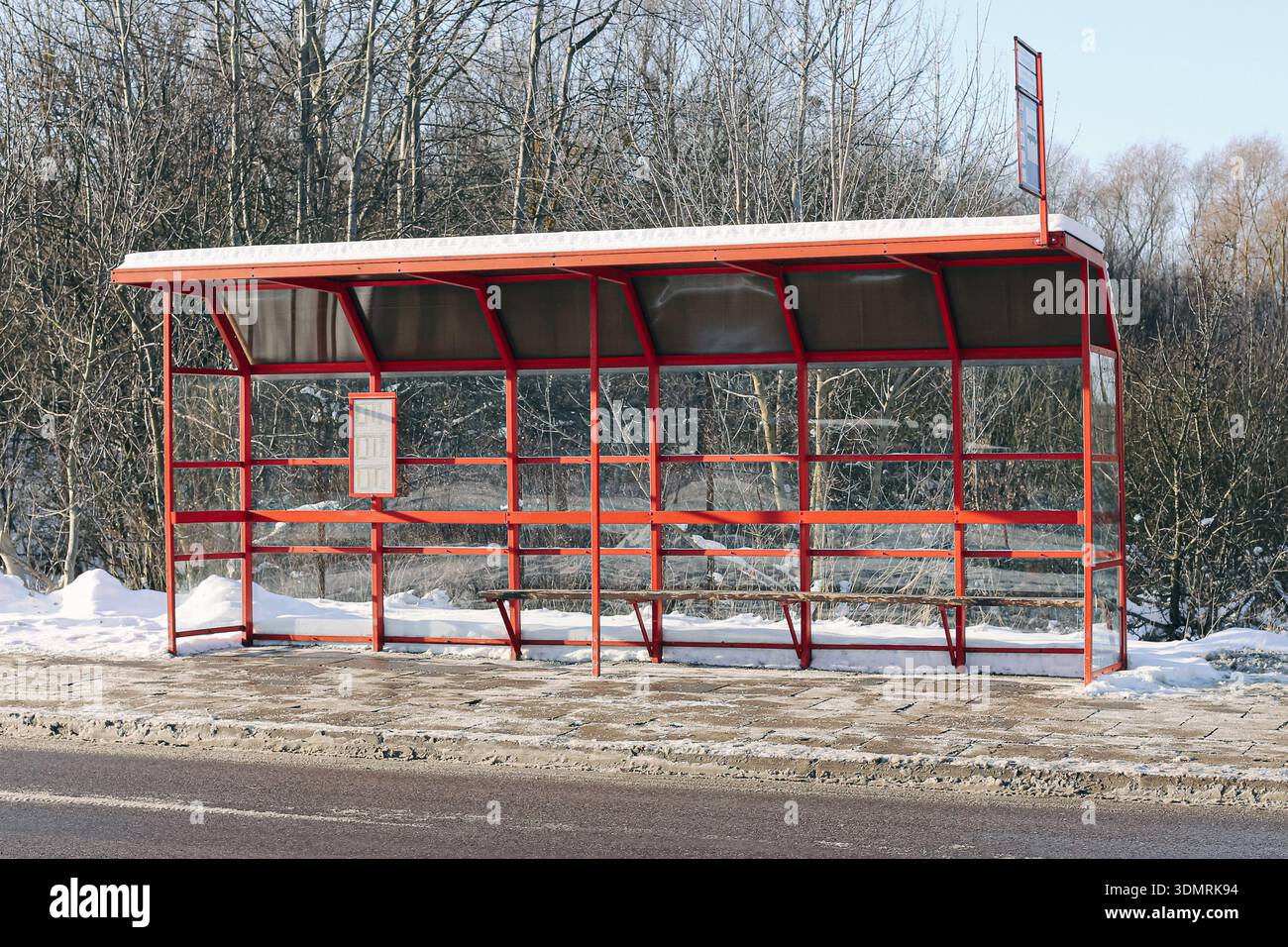 Abri d'arrêt de bus vide pendant la saison hivernale. Station de transport public et paysage urbain enneigé à l'extérieur par temps froid. Banque D'Images