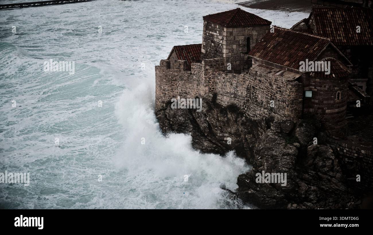 Vagues s'écrasant contre la forteresse en pierre sur la côte rocheuse Banque D'Images
