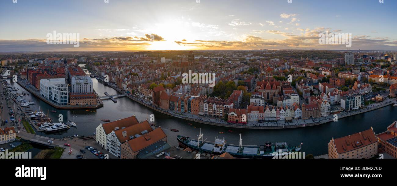 Vue aérienne de la vieille ville de Gdansk au coucher du soleil montre la rivière Motlawa, la grue, l'église de Marys, port de plaisance avec yachts, toits rouges, kayaks, et bateaux d'excursion à wa Banque D'Images