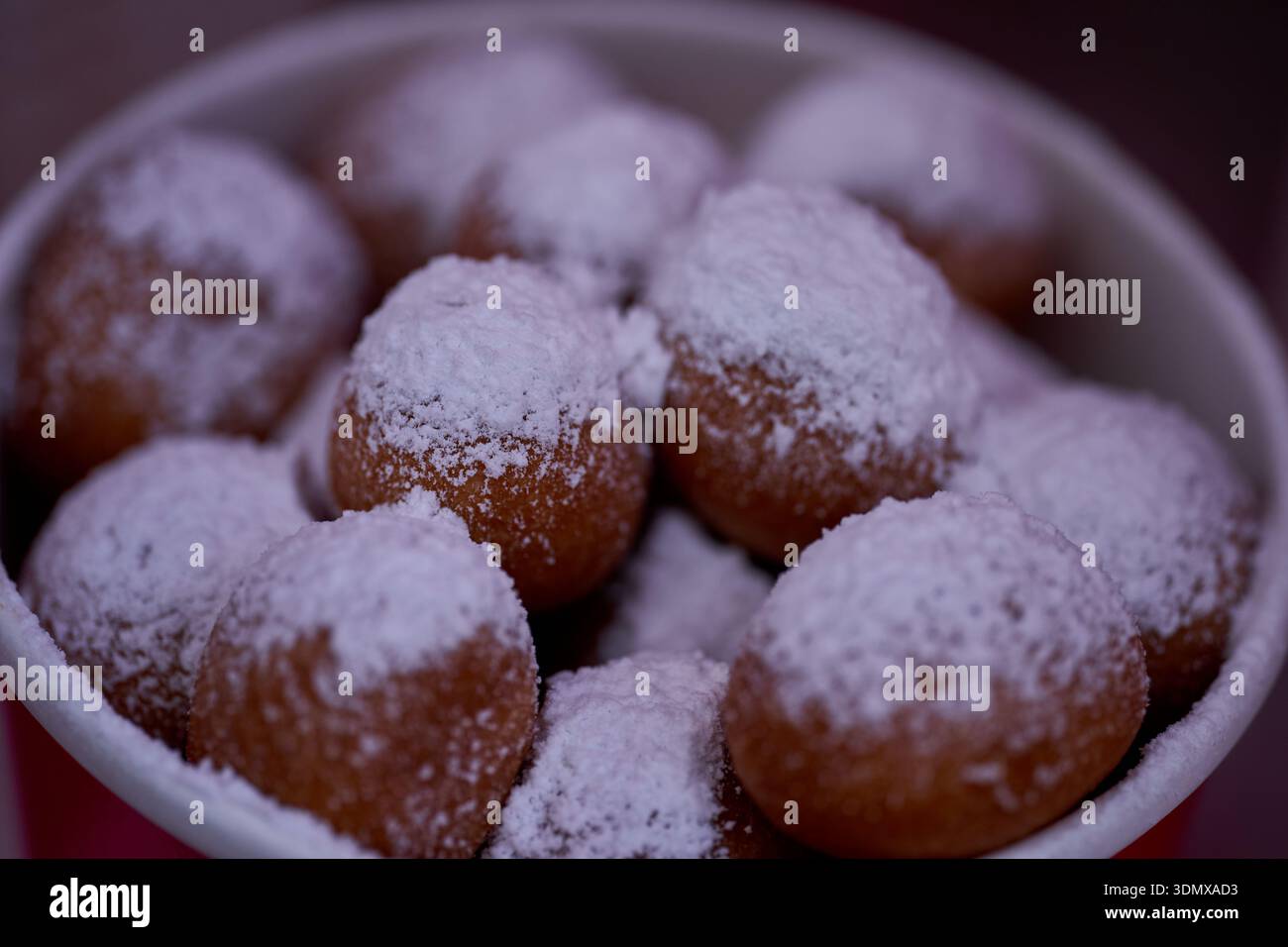 Les beignets ou beignets sont fabriqués à partir d'un mélange de farine, de sucre, de jaunes d'oeufs, de levure et de beurre. Sucre en poudre en forme de boule sur un beignet empilé Banque D'Images