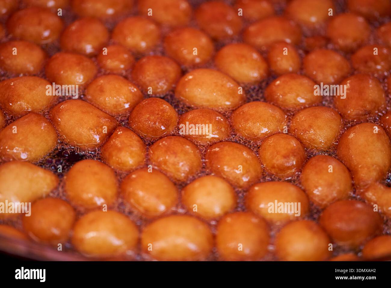Les beignets ou beignets sont fabriqués à partir d'un mélange de farine, de sucre, de jaunes d'oeufs, de levure et de beurre. Sucre en poudre en forme de boule sur un beignet empilé Banque D'Images