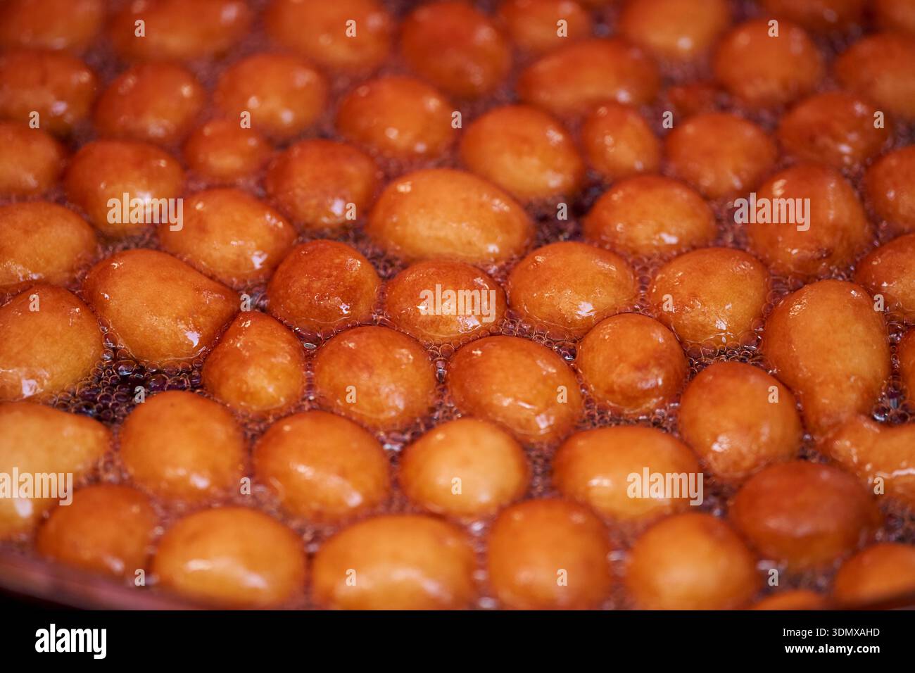 Les beignets ou beignets sont fabriqués à partir d'un mélange de farine, de sucre, de jaunes d'oeufs, de levure et de beurre. Sucre en poudre en forme de boule sur un beignet empilé Banque D'Images