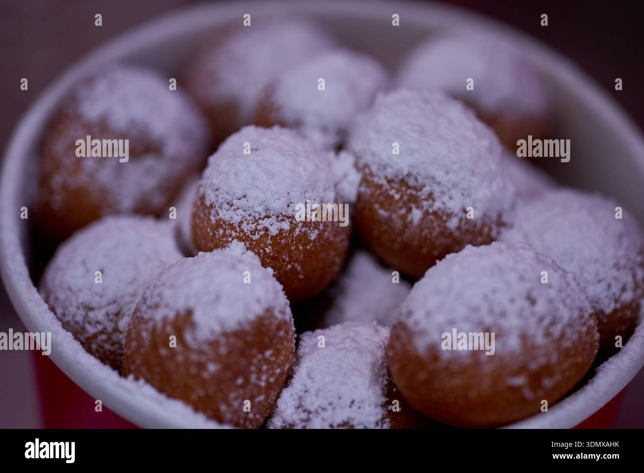 Les beignets ou beignets sont fabriqués à partir d'un mélange de farine, de sucre, de jaunes d'oeufs, de levure et de beurre. Sucre en poudre en forme de boule sur un beignet empilé Banque D'Images