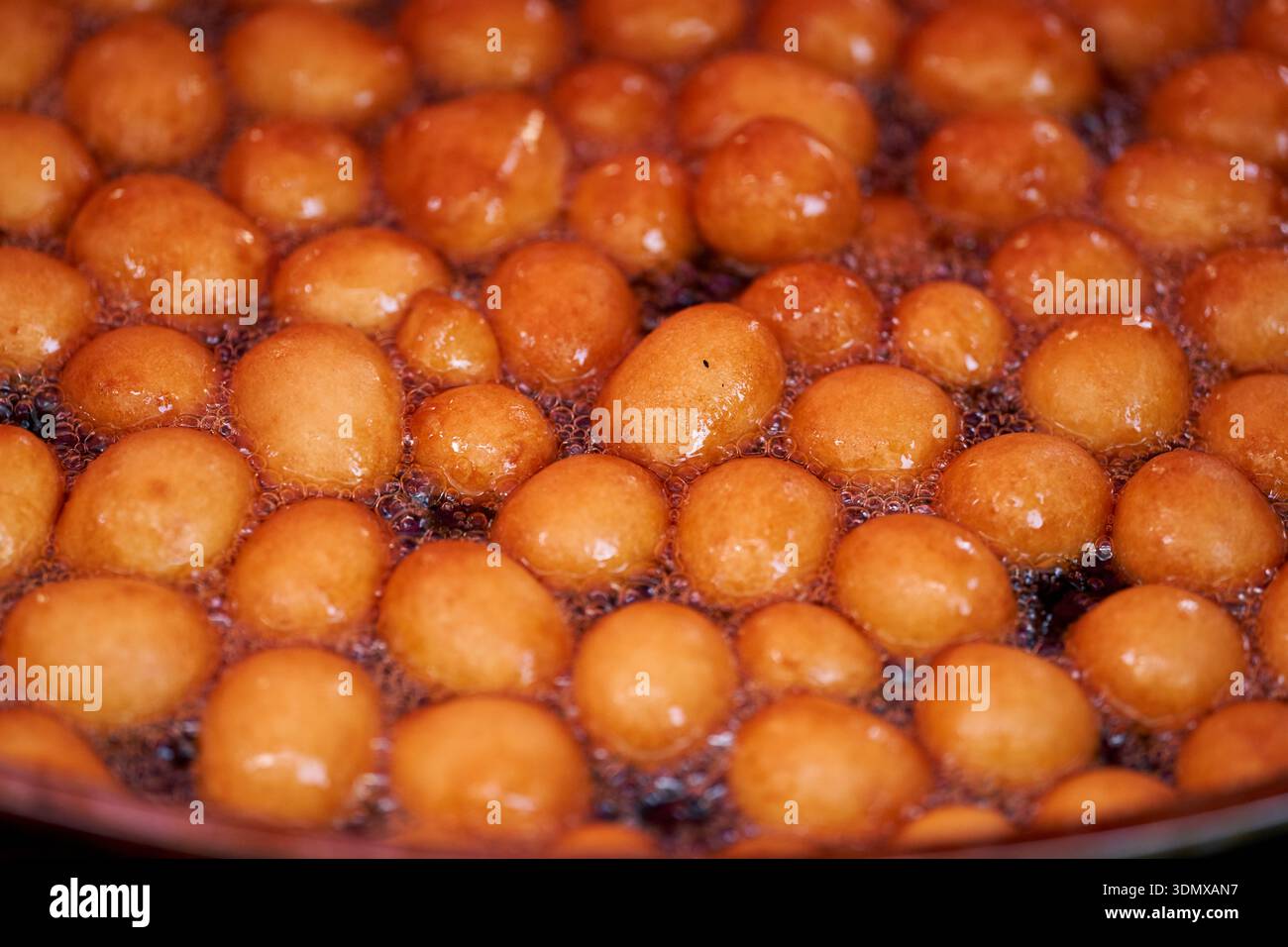Les beignets ou beignets sont fabriqués à partir d'un mélange de farine, de sucre, de jaunes d'oeufs, de levure et de beurre. Sucre en poudre en forme de boule sur un beignet empilé Banque D'Images