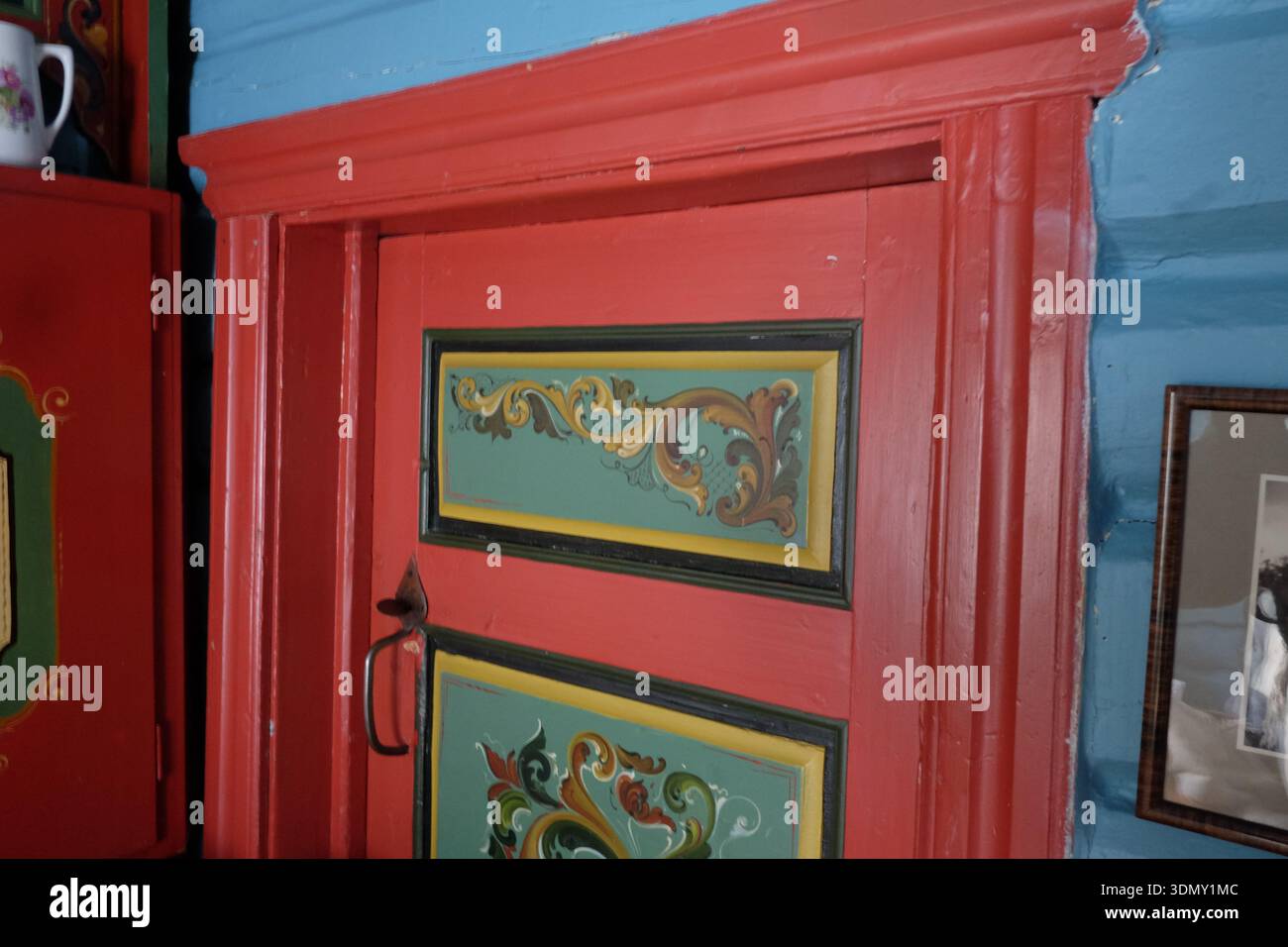 Geilo, Norvège – janvier 2026 : porte en bois traditionnelle peinte au rosemal dans un intérieur de cabane de montagne historique. Banque D'Images