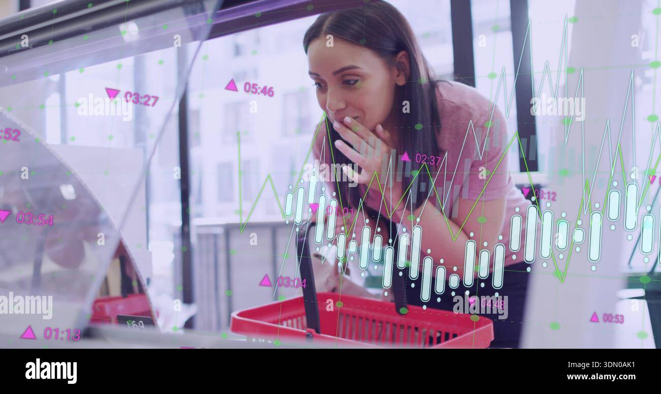 Femme penchée dans le haut rose inspectant le présentoir en verre dans le magasin, tenant le panier rouge et les superpositions du graphique Banque D'Images