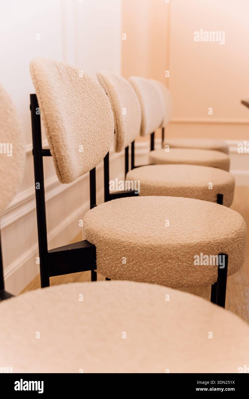 Chaises bouclées beiges modernes à l'intérieur minimaliste avec lumière chaude, flou et espace copie Banque D'Images