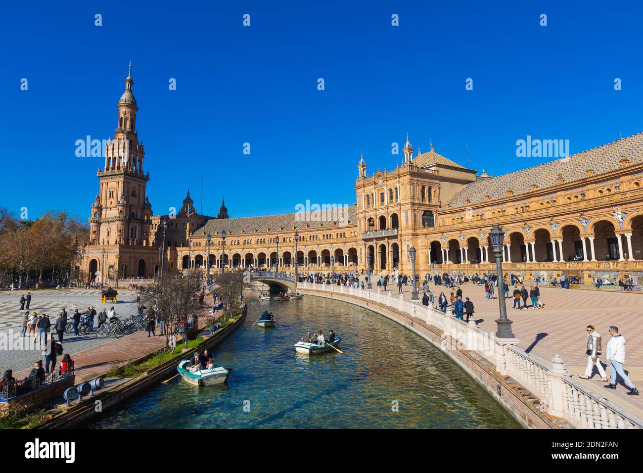 Séville, Espagne - 29 décembre 2025 : les visiteurs se promènent sur la Plaza de Espana, profitant de l'architecture dynamique et des voies navigables paisibles Banque D'Images