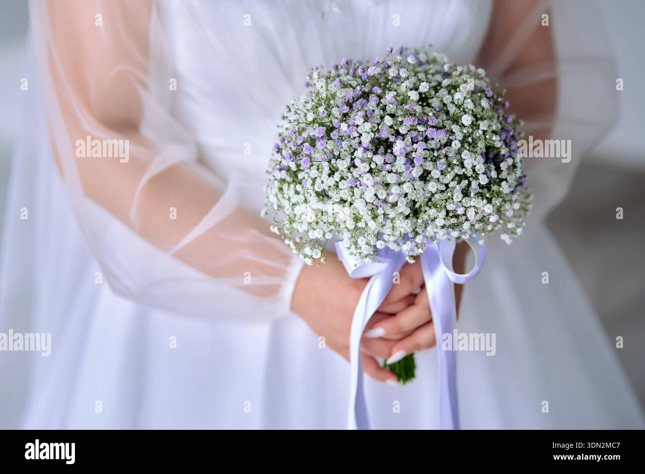 Mariée tenant bouquet de mariage de fleurs de souffle de bébé Banque D'Images