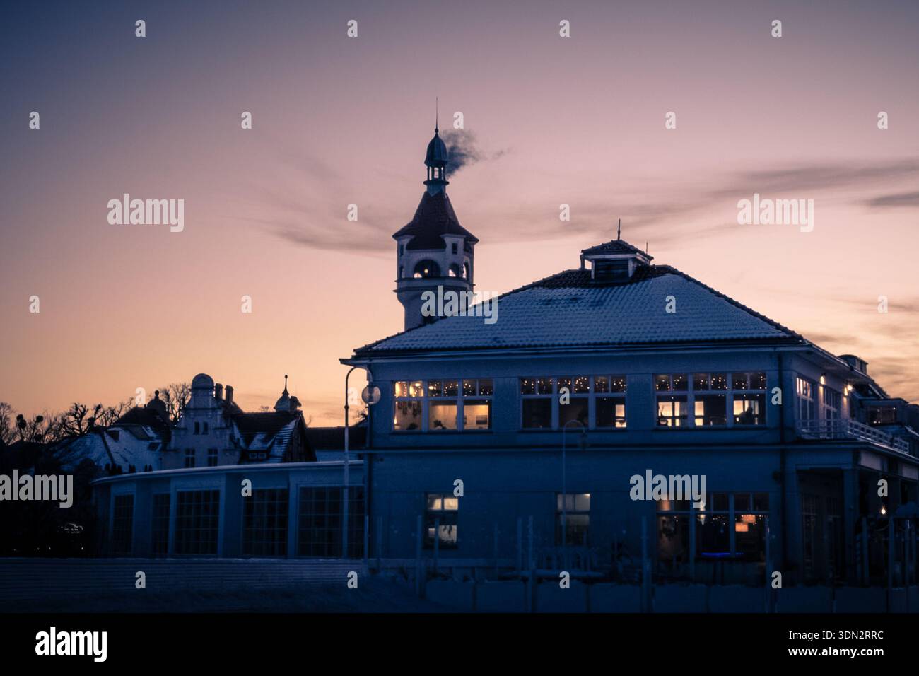 Une scène hivernale atmosphérique mettant en vedette l'historique Grand Hôtel de Sopot, en Pologne, silhouette sur un ciel crépusculaire doux. Banque D'Images