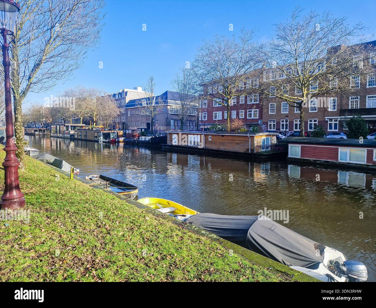 Amsterdam, pays-Bas - 7 février 2026 : Amsterdam maisons flottantes sur le canal. Péniches, front de mer résidentiel. - Image de stock capturée avec un smartphone