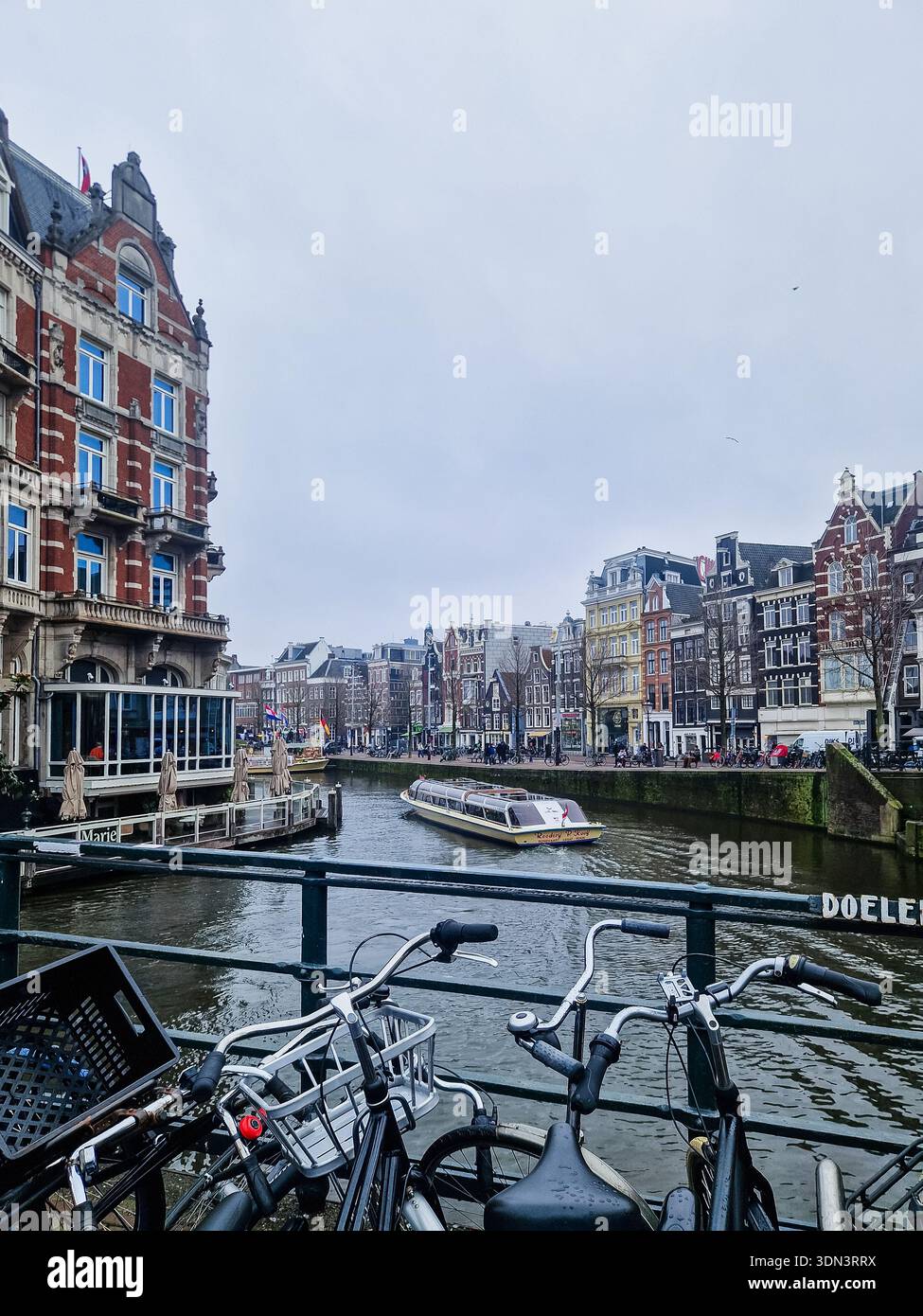 Amsterdam, pays-Bas - 6 février 2026 : vue sur la ville d'Amsterdam avec maisons sur le canal et vélos. - Image de stock capturée avec un smartphone
