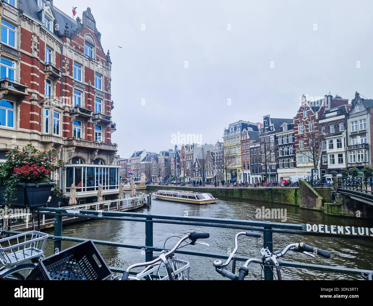 Amsterdam, pays-Bas - 6 février 2026 : vue sur la ville d'Amsterdam avec maisons sur le canal et vélos. - Image de stock capturée avec un smartphone