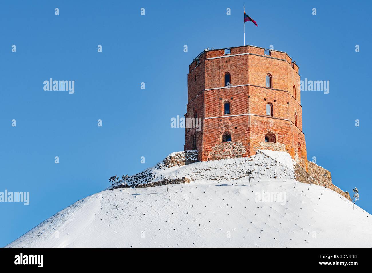 Tour de Gediminas ou château, la partie restante du château médiéval supérieur sur la colline couverte par la neige, Vilnius, Lituanie avec drapeau lituanien Banque D'Images