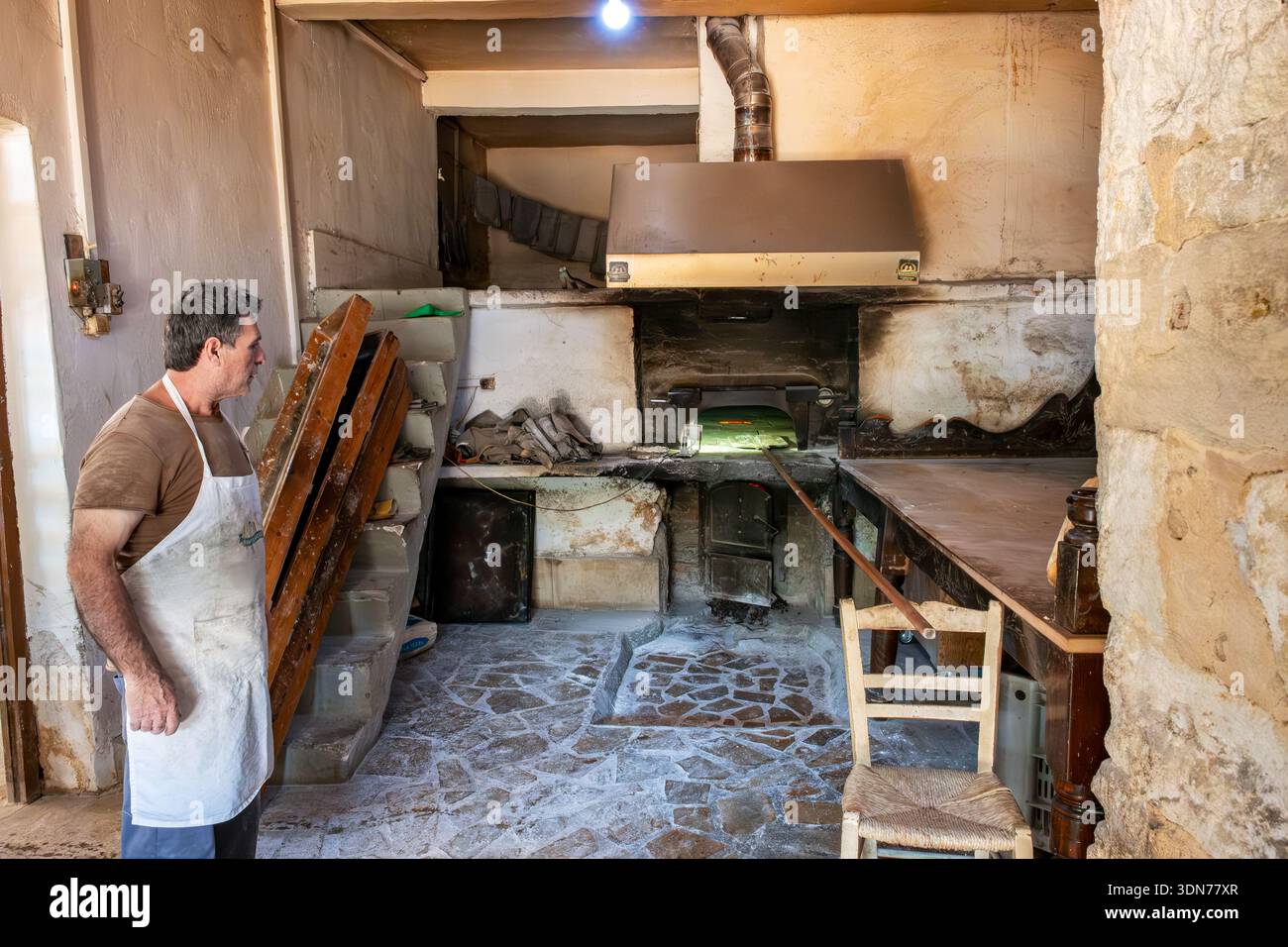 Baker attend que le four chauffe dans une petite vieille boulangerie à Georgioupolis. Crète, Grèce Banque D'Images