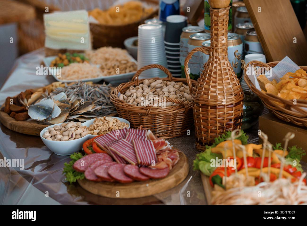 Une vivacité d'inspiration méditerranéenne avec charcuterie, fromages frais, noix rôties, poisson séché et légumes colorés disposés en bois Banque D'Images