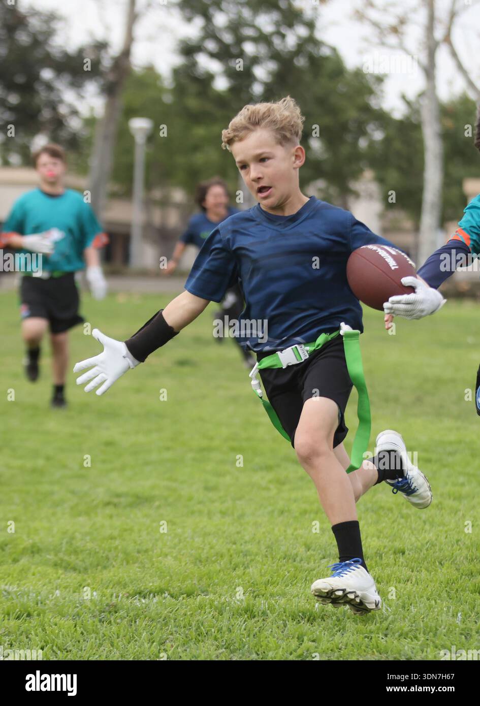 Boy célèbre alors qu'il marque un touchdown dans le drapeau Banque D'Images
