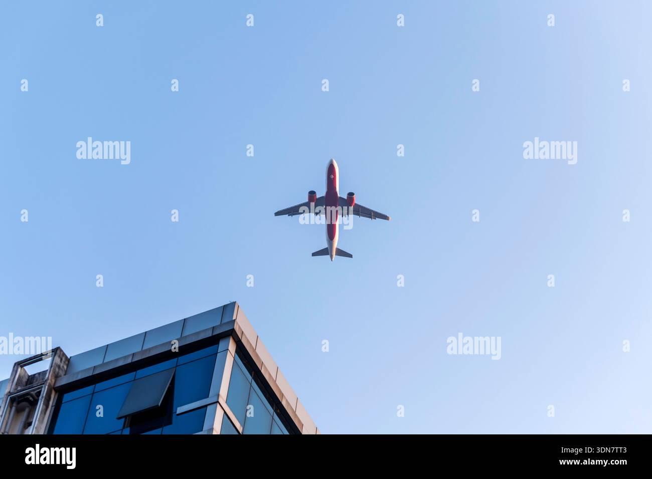 Avion volant au-dessus des gratte-ciel d'affaires bâtissant sur le ciel bleu Banque D'Images