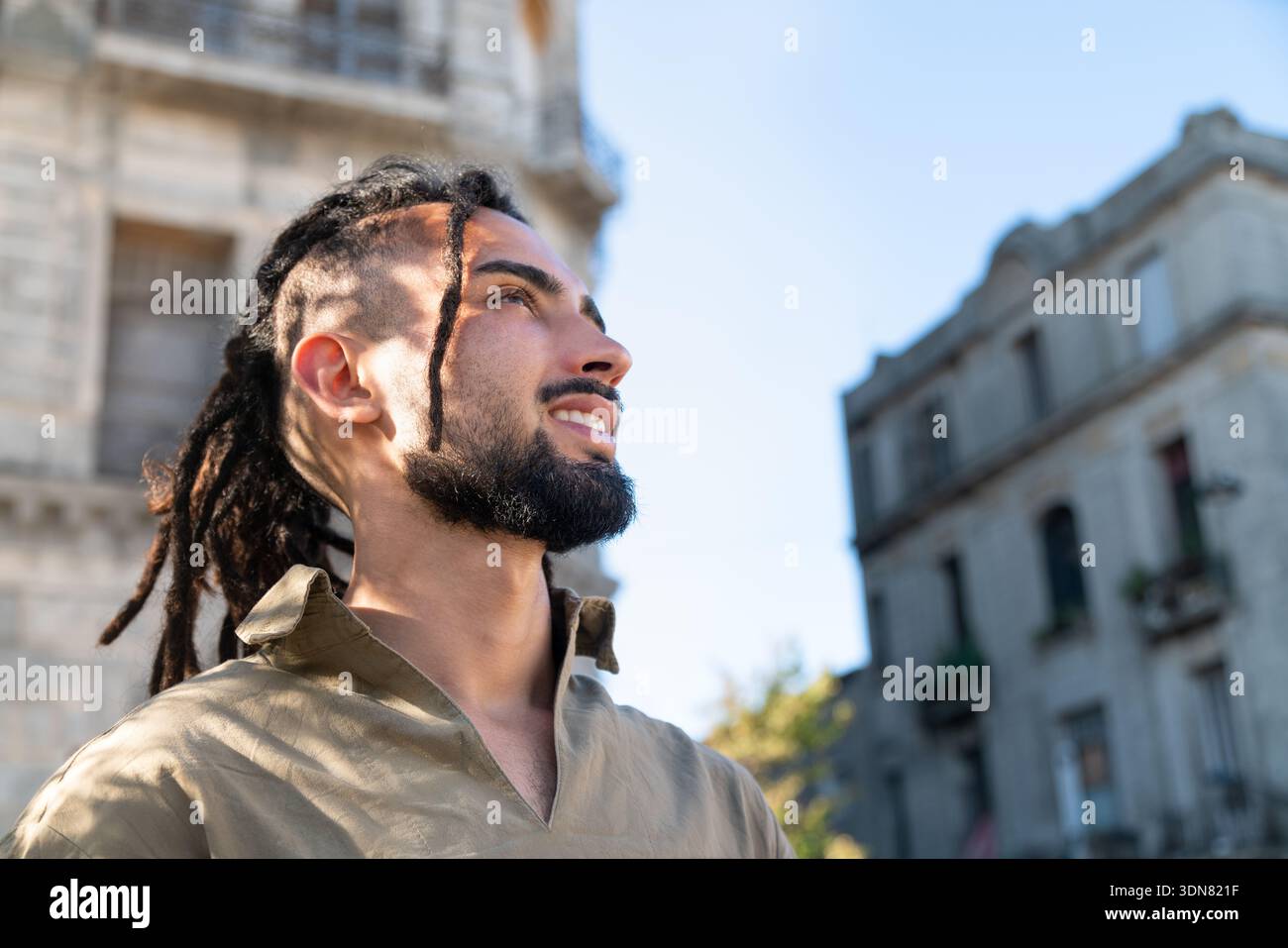 Homme avec des dreadlocks et la barbe regardant dehors, reflétant la liberté et le style de vie Banque D'Images