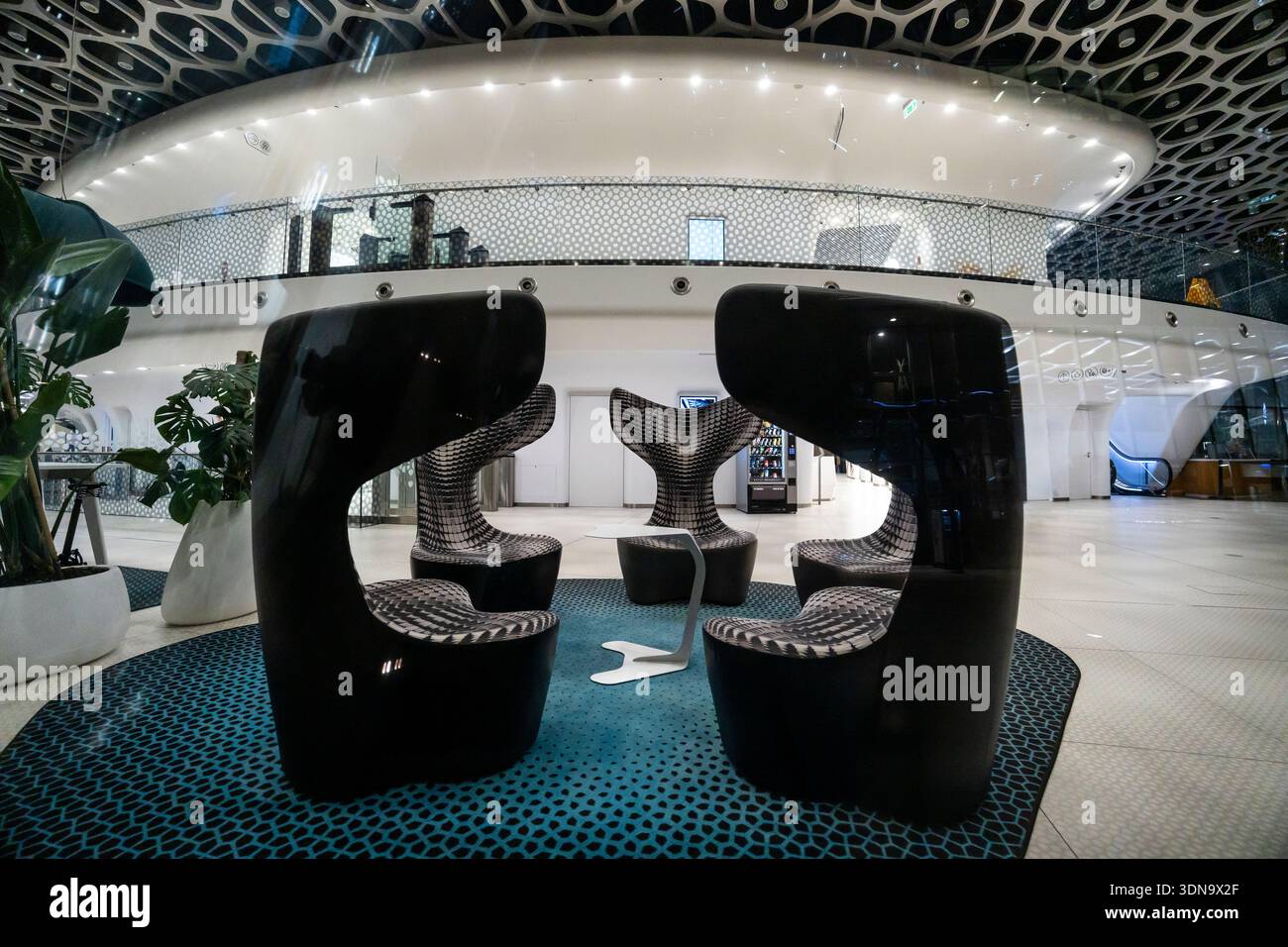 Varsovie, Pologne — hall d'entrée moderne avec des sièges élégants turquoise, un sol en béton élégant, un éclairage au plafond spectaculaire, une architecture contemporaine Banque D'Images
