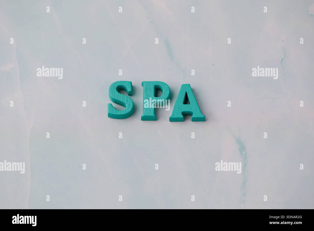 Lettres en bois qui orthographient spa placées sur une surface légère Banque D'Images