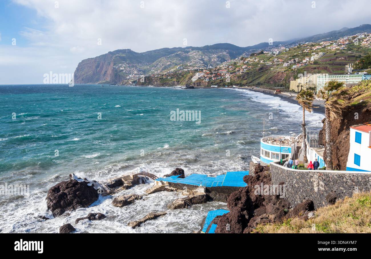 Le restaurant de fruits de mer peint en blanc et bleu au bord du sentier côtier et des piscines naturelles volcaniques sur l'île de Madère, au Portugal. Banque D'Images
