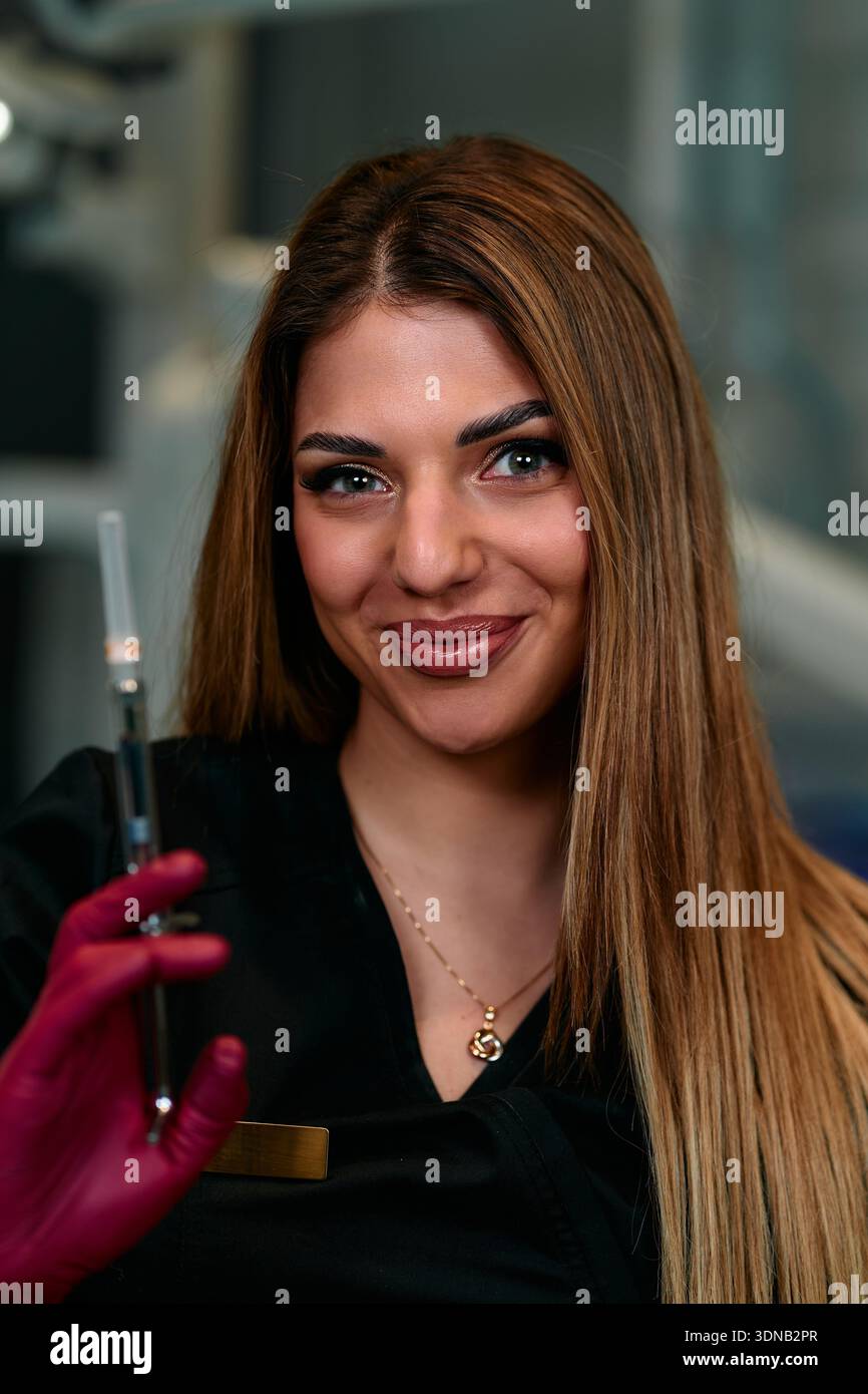 Le professionnel de la santé souriant tient la seringue dans le cadre de laboratoire pour le portrait photo de stock du travailleur médical Banque D'Images