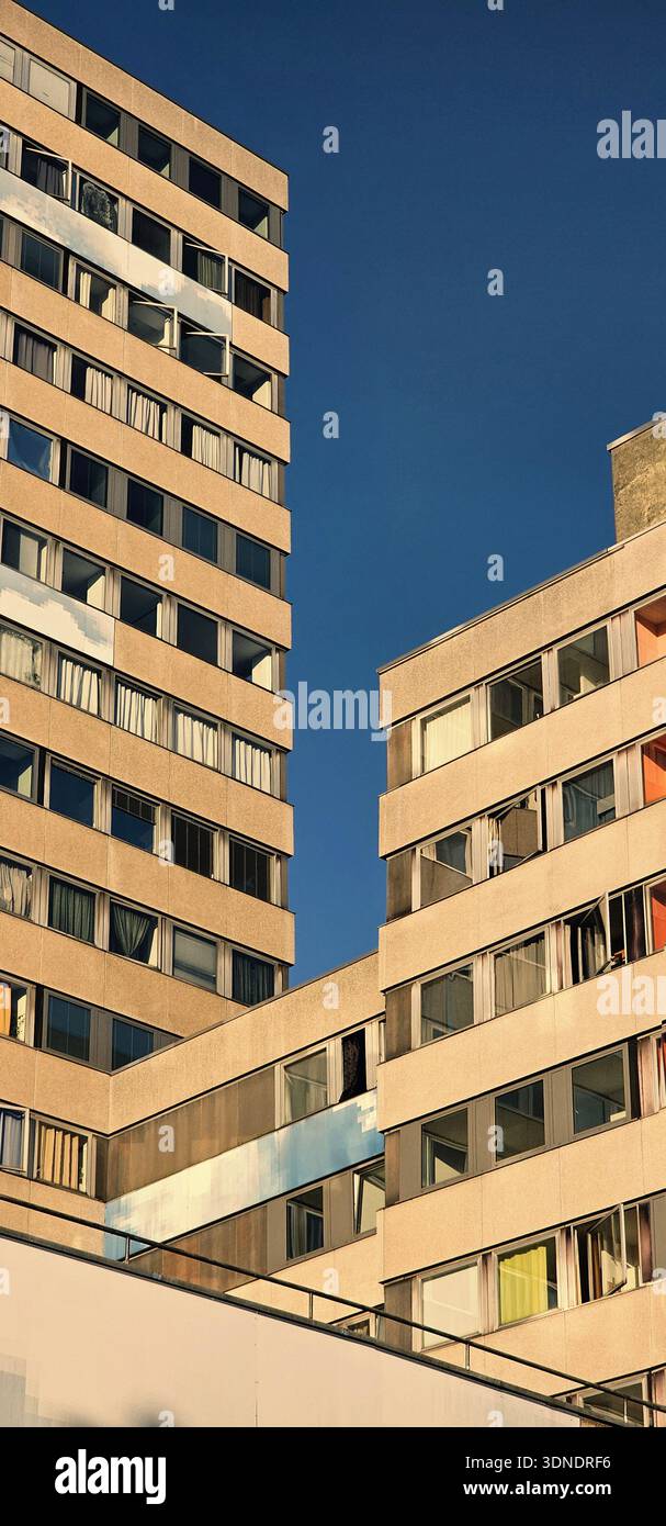 Deux grands bâtiments avec des fenêtres de couleur sable clair. Les bâtiments sont en face d'un ciel dégagé sans nuages. Bâtiments avec fenêtres ouvertes. ph moderniste vertical Banque D'Images