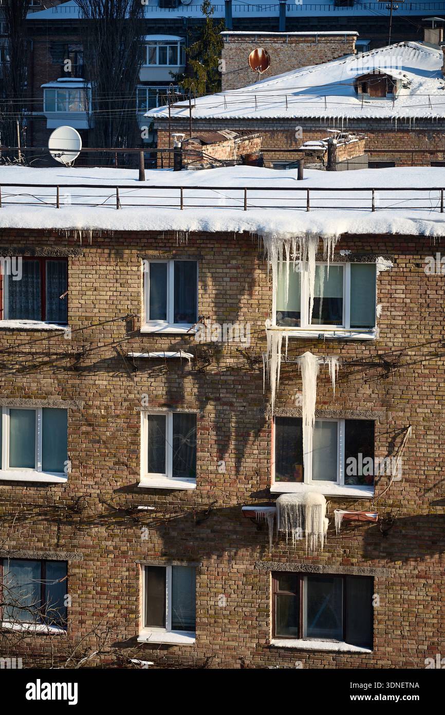 glace d'hiver et glaçons sur le vieux mur de briques, scène de décomposition urbaine Banque D'Images