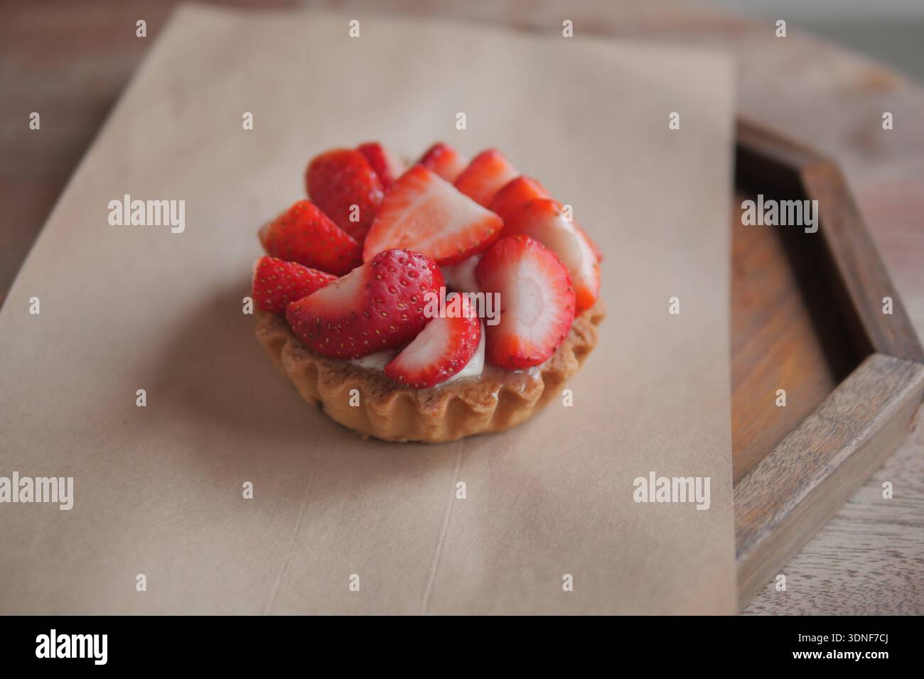 Tarte aux fraises placée sur un plateau en bois dans un café Banque D'Images