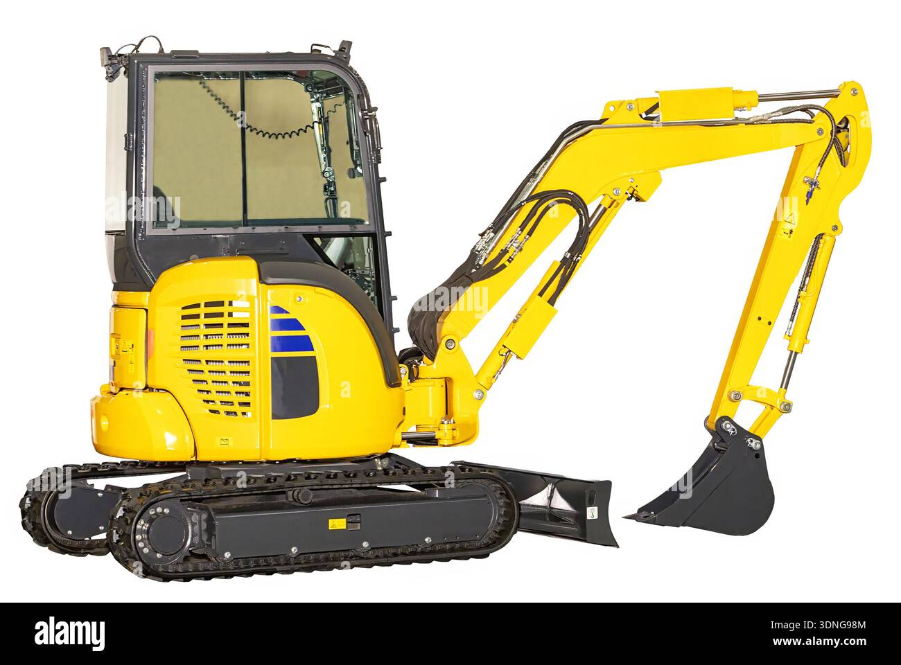 Une mini-pelle jaune vif se trouve sur un chantier de construction, entourée de monticules de terre et d'outils. Banque D'Images
