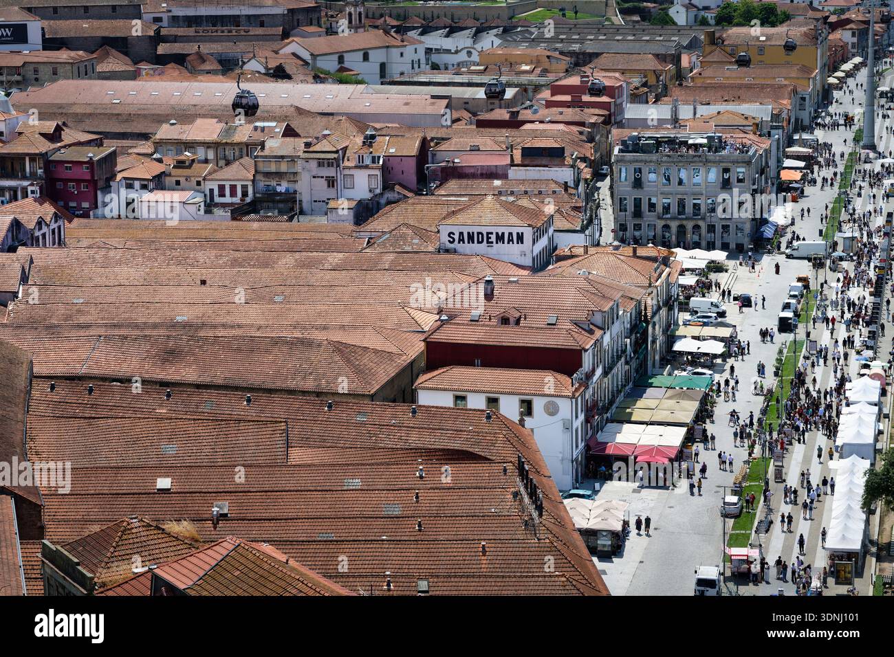 Porto, Portugal 14 juin 2025 : vue en angle élevé sur les pavillons historiques de vin de Porto, les toits en terre cuite et la promenade animée au bord du fleuve Douro à Vila Nova de Banque D'Images
