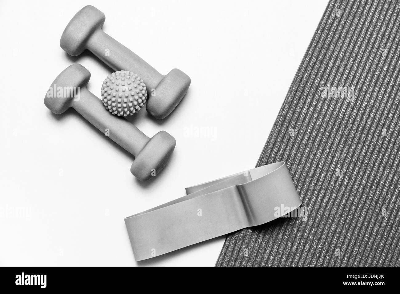 Pose plate monochrome d'appareils de fitness : haltères, bande de résistance, boule de massage. Idéal pour la santé, l'entraînement et les concepts de bien-être Banque D'Images