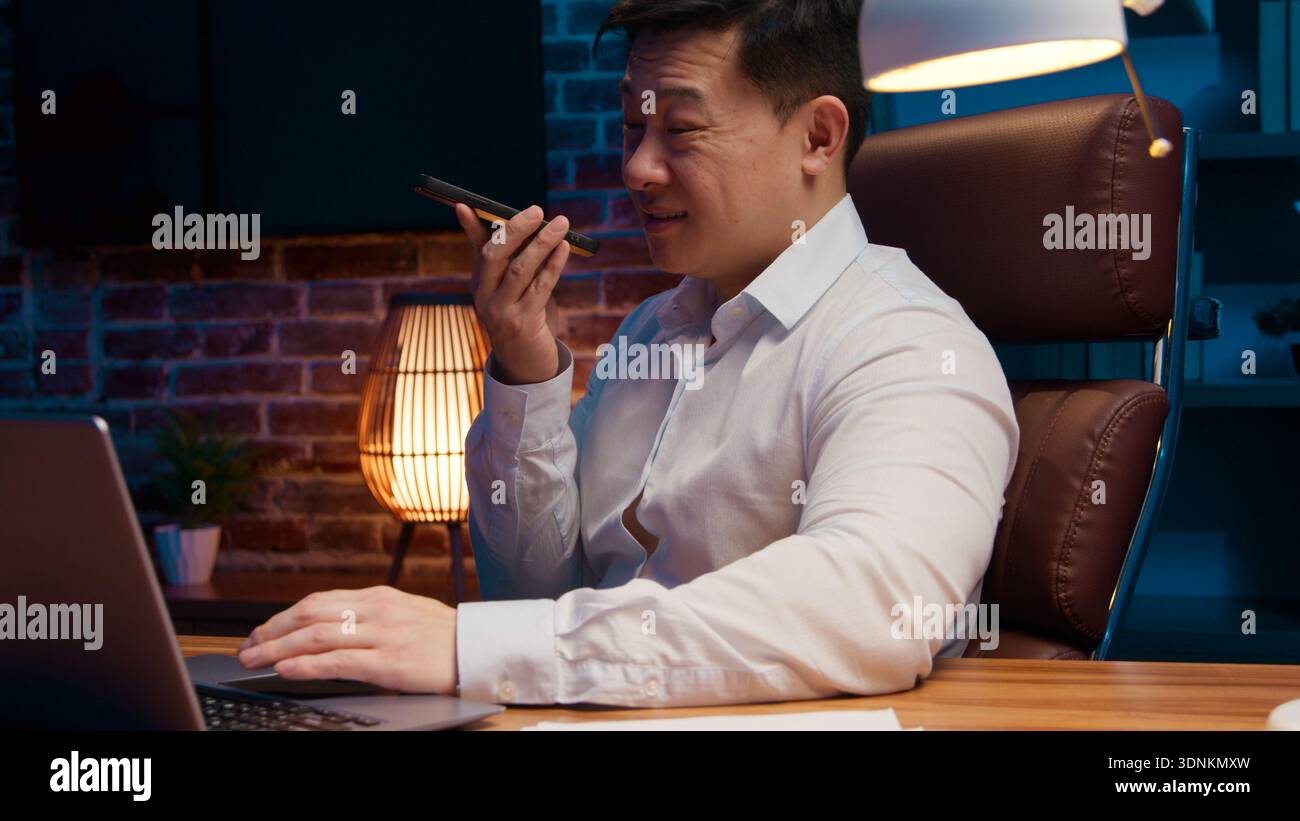 Agacé homme d'affaires asiatique d'âge moyen enregistrant un message audio messagerie vocale homme d'affaires coréen enregistrement vocal en colère Chinois Japonais homme parlant mobile Banque D'Images