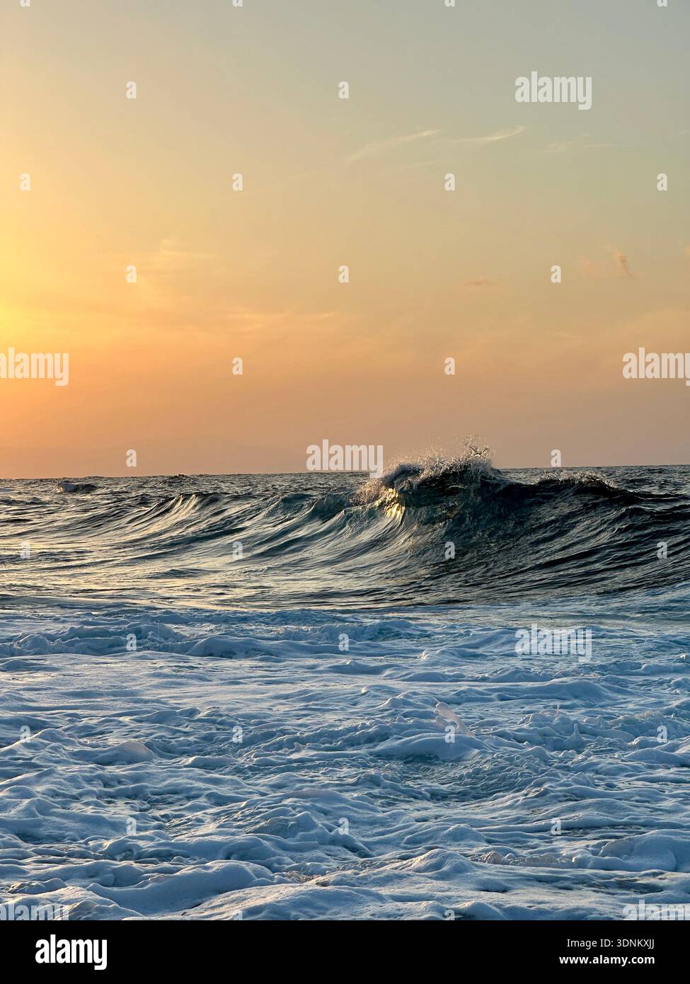 Fais un signe d'adieu : une vague lumineuse se courbe dans la Méditerranée alors que le soleil se couche sur Chypre - Image de stock capturée avec un smartphone