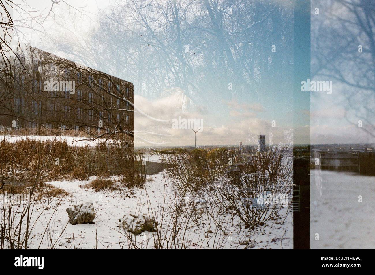 photo double-exposée avec un bâtiment sur un terrain enneigé avec de l'herbe sèche sur film 35 mm Banque D'Images