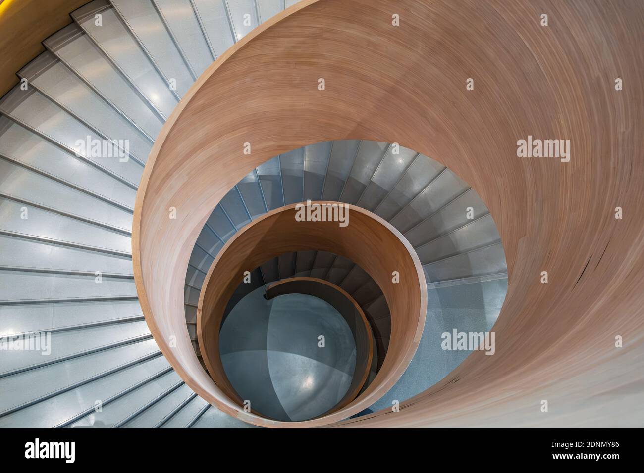 Vue de dessus de l'escalier en colimaçon en bois moderne avec des marches en béton gris et un design architectural minimaliste. Arrière-plan d'architecture abstraite. Organique et Banque D'Images