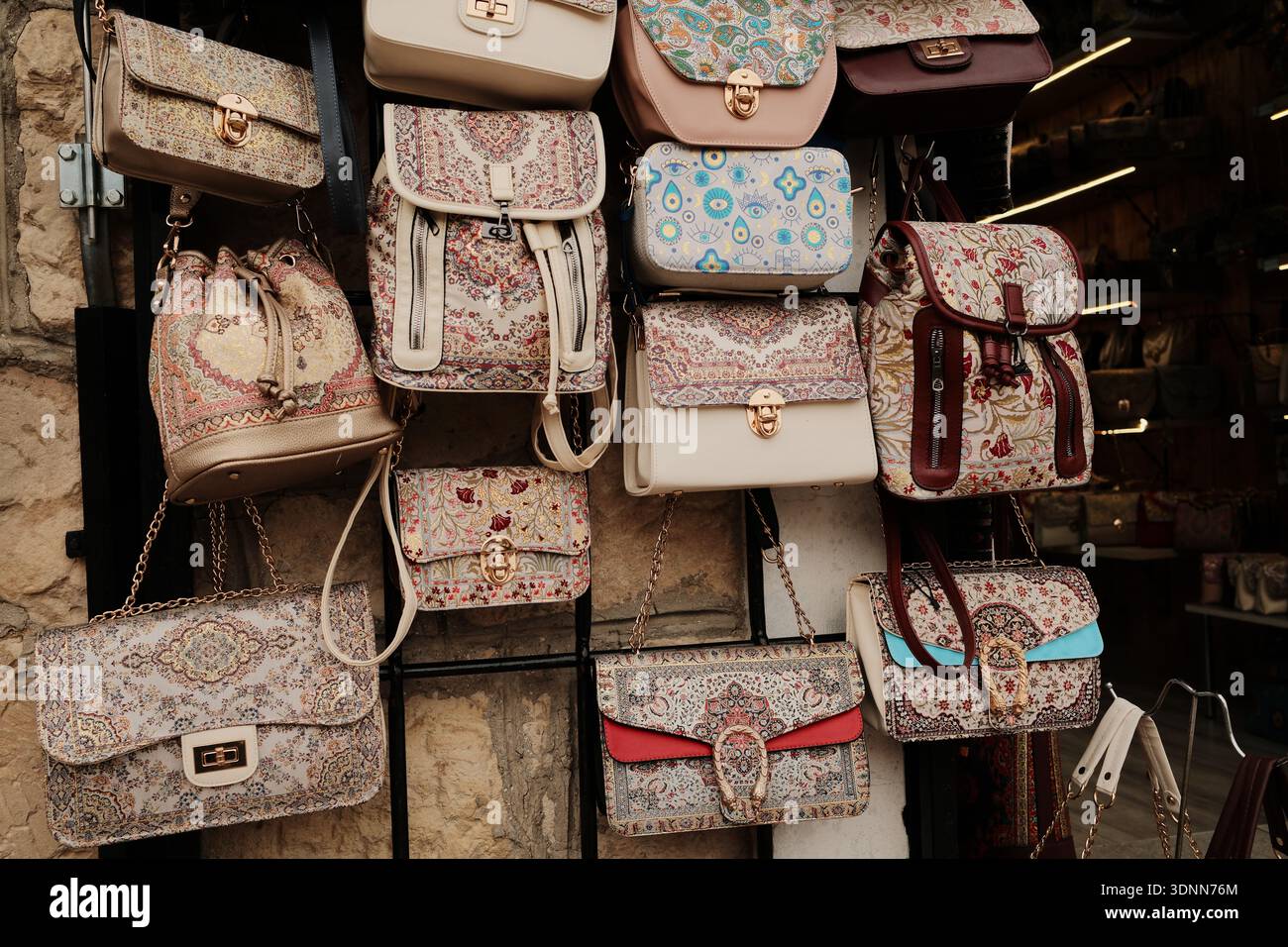 Sacs à main colorés et à motifs exposés sur un mur de marché, arborant des designs textiles traditionnels et des détails décoratifs. Étalage de souvenirs de rue avec Banque D'Images