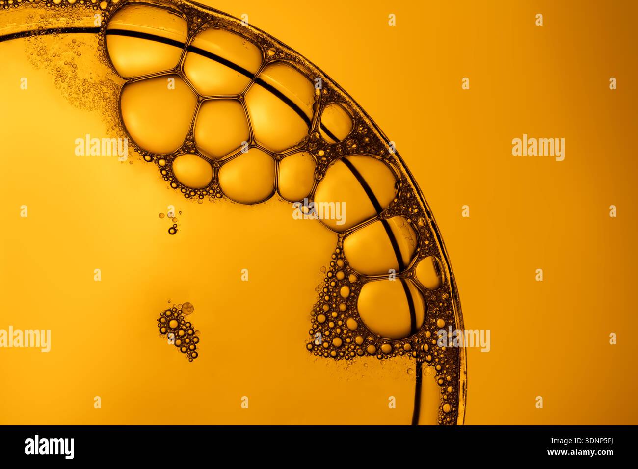 Une image macro saisissante mettant en vedette un groupe de bulles de savon sur un fond orange éclatant. Les bulles créent des motifs complexes et des reflets, highl Banque D'Images